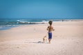 African man with dreadlocks hair running with his dog on the beach of Jeffreys Bay Royalty Free Stock Photo