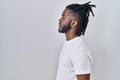 African man with dreadlocks wearing casual t shirt over white background looking to side, relax profile pose with natural face Royalty Free Stock Photo