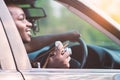 African man driver holding a film camera and smiling while sitting in a car with open front window Royalty Free Stock Photo