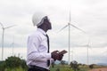 African man engineer holding laptop tablet with wind turbine Royalty Free Stock Photo