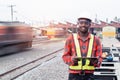 African man engineer using tablet to report of Train Timetables for control a the train on railway