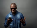 African man excited at mobile phone