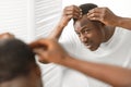 African Man Having Dandruff Problem Looking In Mirror In Bathroom Royalty Free Stock Photo