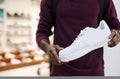 African man holding a white sneaker