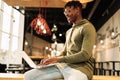 African man with laptop sitting at desk, with laptop on his lap. distance communication, training. online communication Royalty Free Stock Photo