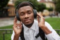 African man listening music in headphones with closed eyes and dreaming. Royalty Free Stock Photo