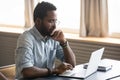 African man looking at laptop screen thinking over received email