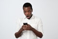 African man looking at phone seeing shocking news or photos with surprised emotion on his face Royalty Free Stock Photo