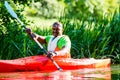 African Man paddling with canoe on forest river Royalty Free Stock Photo