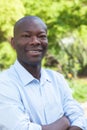 African man in a park with crossed arms looking at camera Royalty Free Stock Photo