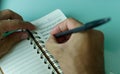 African man  pen in hand to write on  notebook. Royalty Free Stock Photo
