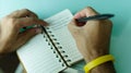 African man  pen in hand to write on  notebook. Royalty Free Stock Photo