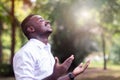 African man praying for thank god with light flare in the green nature Royalty Free Stock Photo