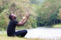 African man praying for thank god with light flare in nature Royalty Free Stock Photo