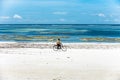 African man riding a bike on the beach Royalty Free Stock Photo