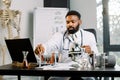 African man scientist researcher sitting at the table in lab and doing dna test, analisys of blood samples or new Royalty Free Stock Photo