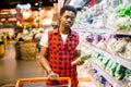 African man shopping in vegetable section at supermarket. Black man doing shopping at market while buying vegetables Royalty Free Stock Photo