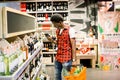 African man shopping in wine section at supermarket. Black man doing shopping at market while buying wine. Handsome guy Royalty Free Stock Photo