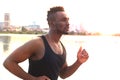 African man in sports clothing running while exercising, in beach outdoor portrait, at sunset or sunrise. Runner.