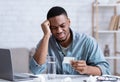 African Man Suffering From Headache Reading Pills Instruction At Workplace Royalty Free Stock Photo