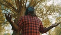 African man takes a big breath rises hands and look up a the sky. Sun rays comming through the tree. Hope and prayer Royalty Free Stock Photo