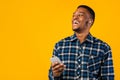 African Man Talking On Cellphone Hands-Free Using Earbuds, Studio Shot