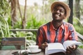 African man thinking and reading a book with holding a hot coffee.World book day Concept