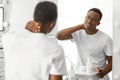 African Man Touching Aching Neck Suffering From Pain In Bathroom Royalty Free Stock Photo