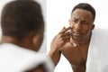 African Man Touching Acne Pimple On Face Standing In Bathroom Royalty Free Stock Photo