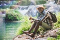 African Man Traveller with backpack sitting and relaxing freedom at the waterfall Royalty Free Stock Photo