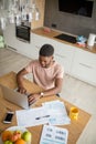 African man using laptop while caucasian girlfriend standing lonely at kitchen Royalty Free Stock Photo