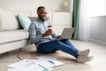 African Man Using Laptop Sitting On Floor Working At Home Royalty Free Stock Photo