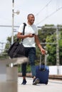 African man walking on train station with suitcase Royalty Free Stock Photo