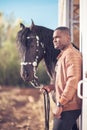 African Man wearing sunglasses near black horse in hangar Royalty Free Stock Photo