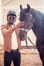 African Man wearing sunglasses near black horse in hangar Royalty Free Stock Photo