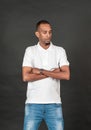 An african man wearing white blank polo shirt, doing a simple pose with both of his hand folded on his chest Royalty Free Stock Photo