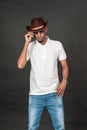 An african man wearing white blank polo shirt with a hat and glasses, doing a simple pose Royalty Free Stock Photo