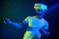 African Man in white, wearing VR Headset on green blue dual color background.