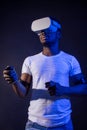 African Man in white, wearing VR Headset on green blue dual color background.