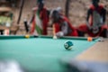 African masai men playing open air billiard pool in the village Sengare Sero at Masailand