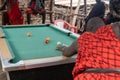 African masai men playing open air billiard pool in the village Sengare Sero at Masailand