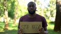 African man showing stop racism sign, national problem, equal rights, abuse