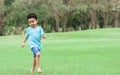 African mixed race adorable curly hair little boy running and playing in outdoor backyard, green field, park, garden with Royalty Free Stock Photo