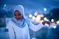 African modern Muslim woman in night at balcony