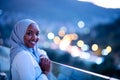 African modern Muslim woman in night at balcony