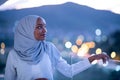 African modern Muslim woman in night at balcony