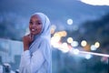 African modern Muslim woman in night at balcony