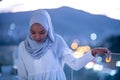 African modern Muslim woman in night at balcony