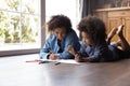 African mom and daughter lying on floor draw in sketchbook Royalty Free Stock Photo