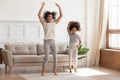 African mom with kid girl jumping dancing in living room Royalty Free Stock Photo